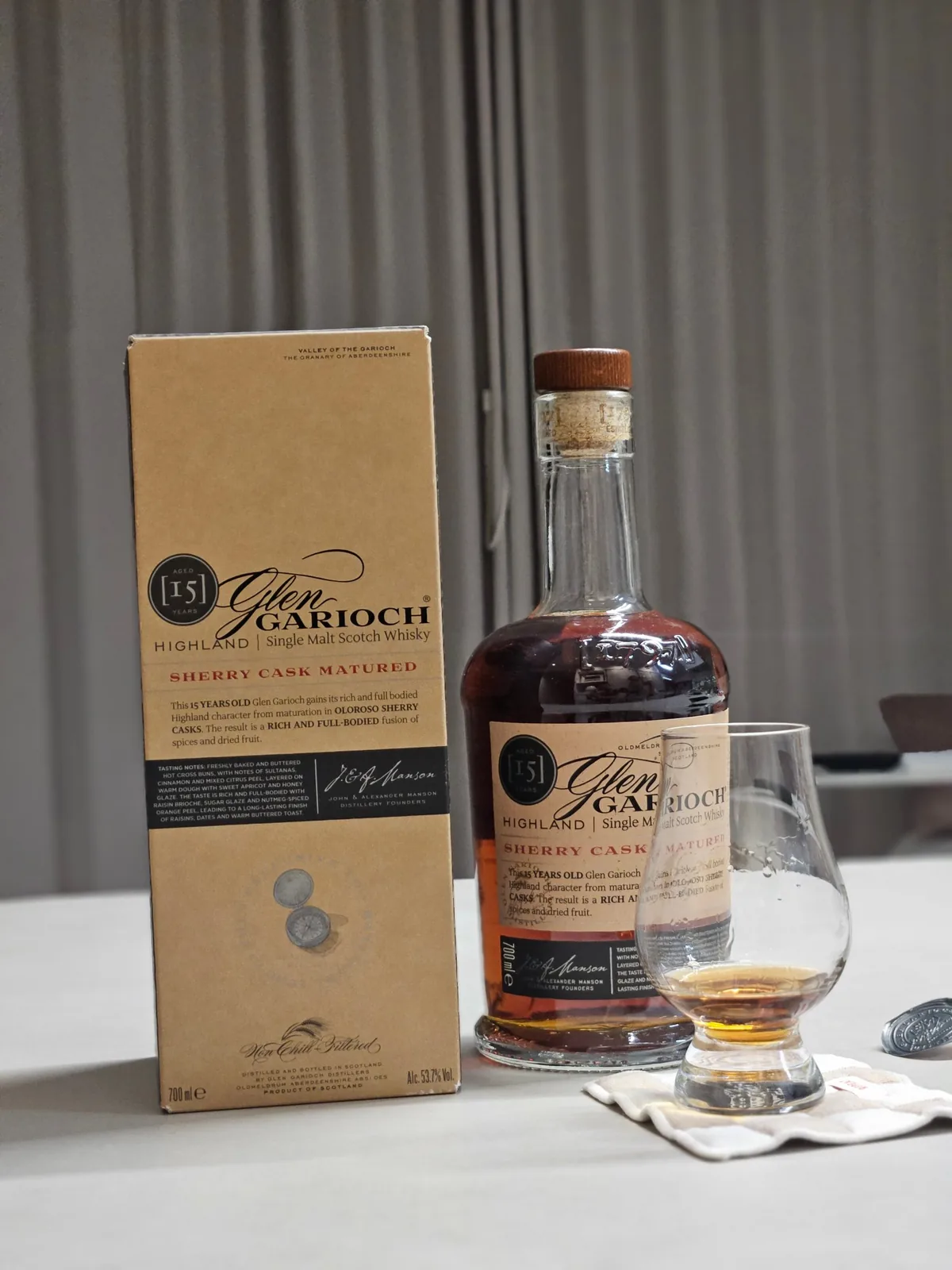 A box and bottle of Glen Garioch 15 Year Old Sherry Cask next to a Glencairn glass of whisky on a table
