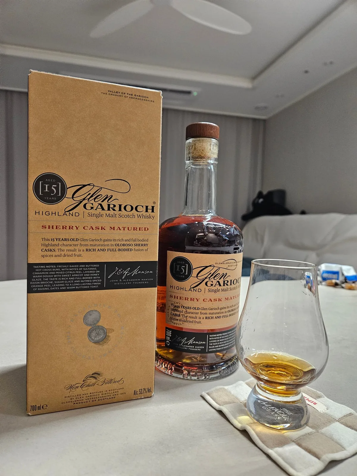 A Glen Garioch 15 Year Old box and bottle on a living-room table with an amber dram in a Glencairn glass