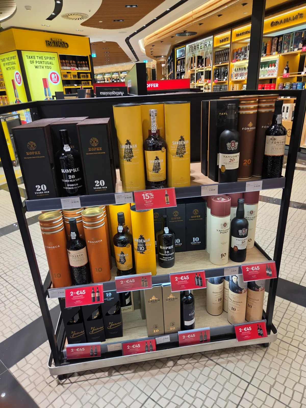A promotion stand of Kopke, Sandeman, Taylor's and Fonseca 10 and 20 year old tawny ports with "2 for €45" price tags at Lisbon Airport duty free