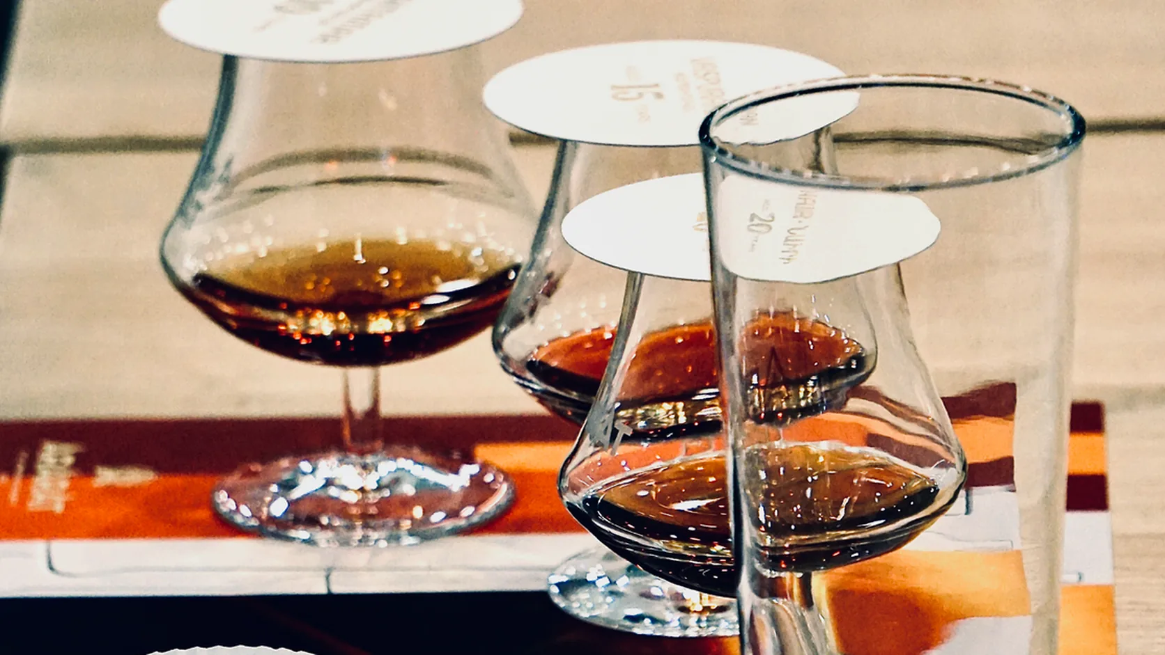 Actual photos comparing the color and aroma of whisky in several glasses on a tasting mat